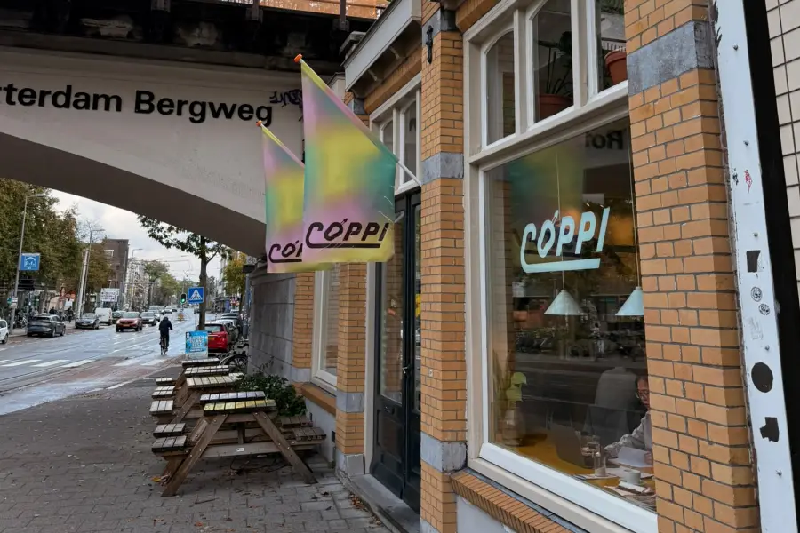Outside COPPI Koffie & Fietsen in Rotterdam, showing outdoor seating for laptop-friendly sessions.