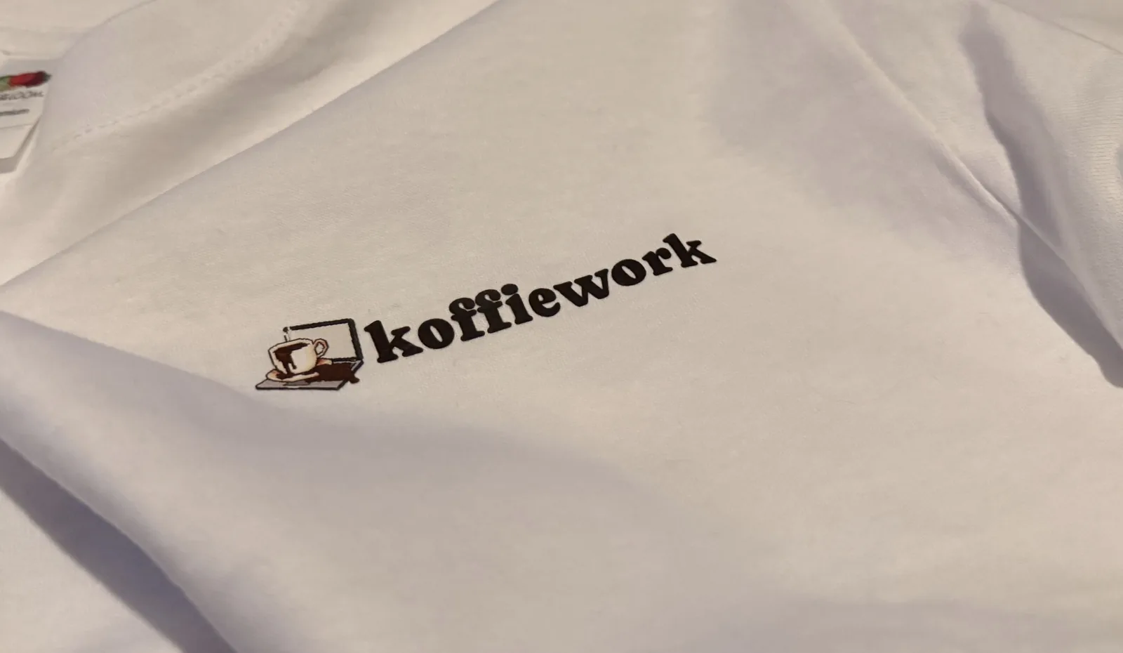 Close-up of the koffiework chest logo printed on the white T-shirt